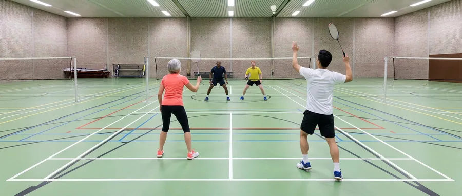 Een speler haalt uit voor een bovenhandse slag in het dubbelspel, zijn partner staat voor hem bij het net