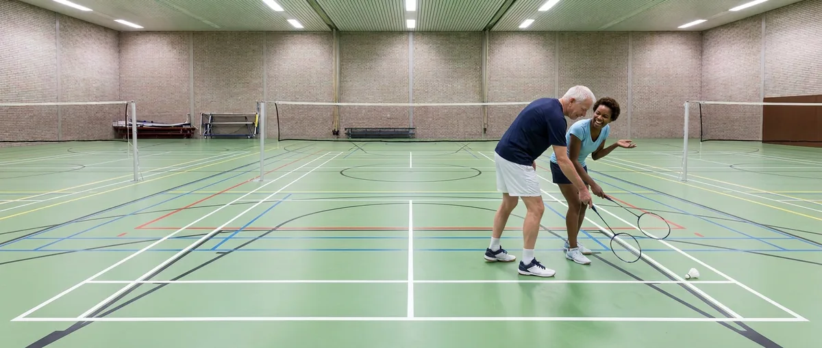 Twee spelers kijken samen naar een shuttle die op de lijn is geland en wijzen ernaar